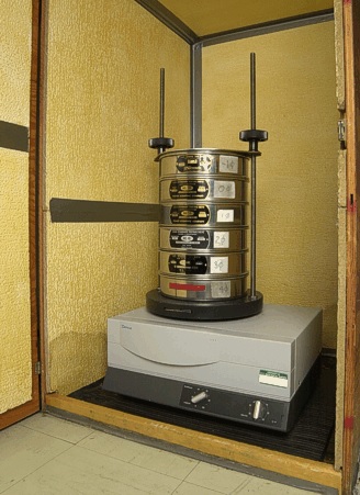 A commercial sieve shaker with a stack of various sieve sizes.