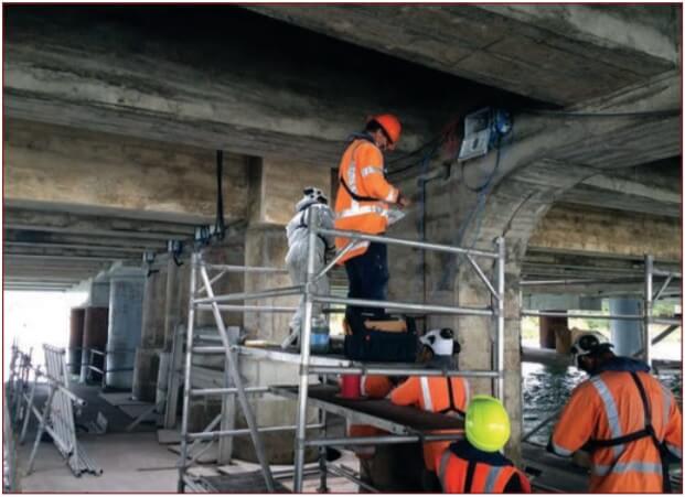 workers repairing concrete bridge