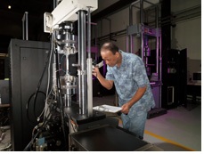 Figure 1. A technician monitoring fatigue crack growth testing with a hydraulic fatigue tester.