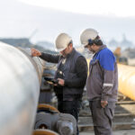 Non-destructive testing technicians checking the welds of a pipe.