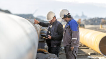 Non-destructive testing technicians checking the welds of a pipe.