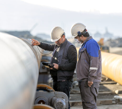 Non-destructive testing technicians checking the welds of a pipe.
