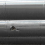 Mechanical damage on a steel pipe, which in turns leads to material failure such as brittle cleavage fractures.