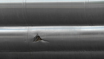 Mechanical damage on a steel pipe, which in turns leads to material failure such as brittle cleavage fractures.