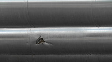 Mechanical damage on a steel pipe, which in turns leads to material failure such as brittle cleavage fractures.