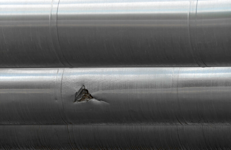 Mechanical damage on a steel pipe, which in turns leads to material failure such as brittle cleavage fractures.